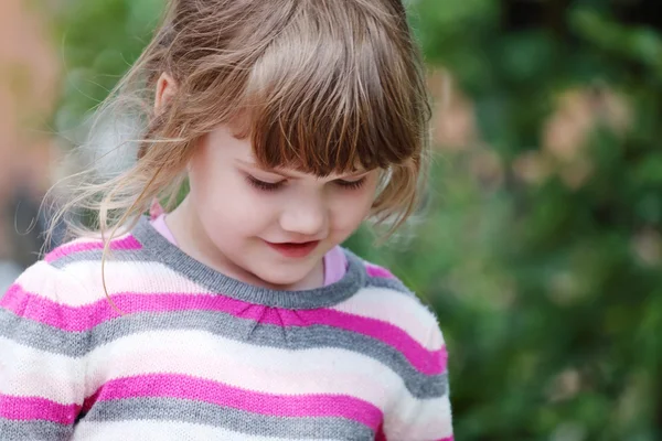 Portrait of young happy smiling girl in striped sweater looking — Stock Photo, Image