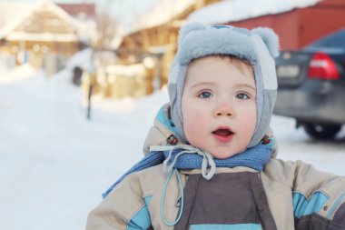 Küçük çocuk sıcak tulum giyen VI kışın, arabanın yakınında standları