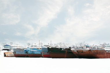 Eski ve paslı büyük yük gemileri kış bulutlu, donmuş nehir üzerinde