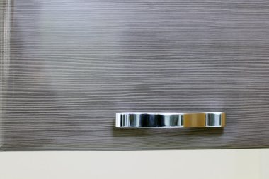 Parlak krom sap üzerinde kahverengi ahşap kapı dolap üzerinde. Yakın çekim