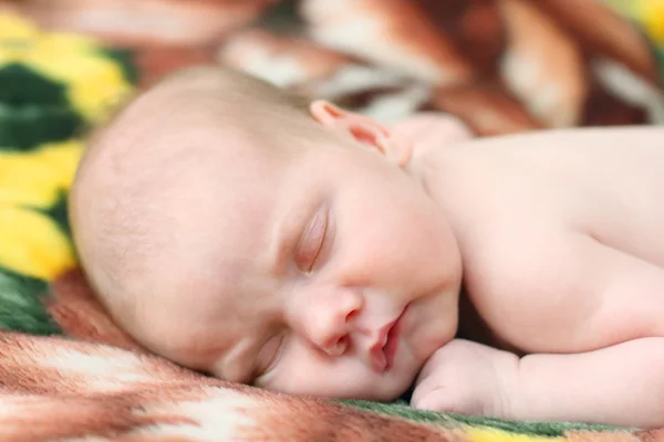 Peaceful baby lying on bed with soft brown blanket while sleepin — Stock Photo, Image