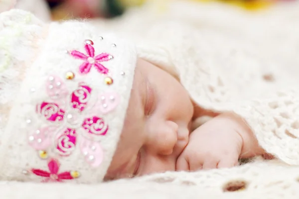 Cute baby lying in hat on bed under soft white knitted shawl whi — Stock Photo, Image