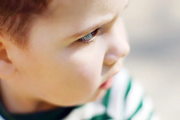 Serious little handsome boy looks at camera in park. Shallow dof — Stock Photo, Image