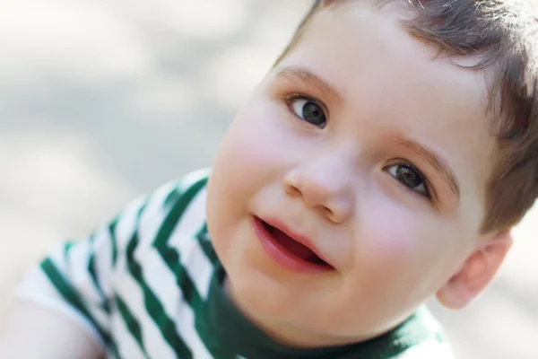 Piccolo ragazzo carino alza gli occhi al sole giorno d'estate all'aperto. Poco profondo fare — Foto Stock