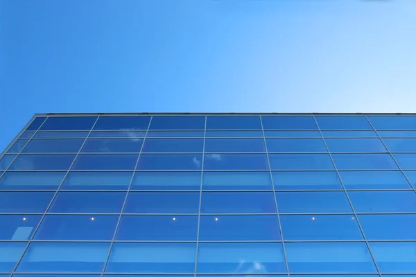 Pared de cristal del edificio con el reflejo del cielo azul con cl pequeño — Foto de Stock