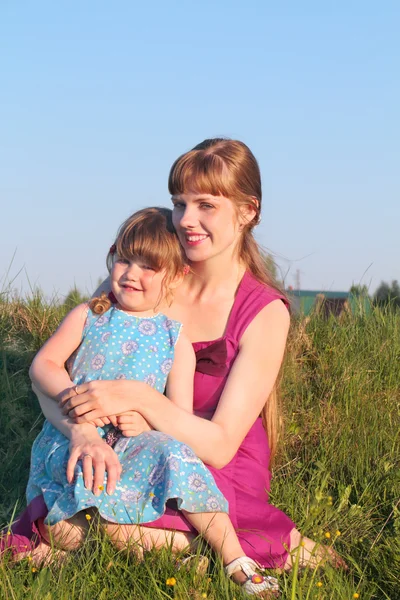 Anne kızıyla yaz güneşli d çimlere oturup birlikte gülümseyen — Stok fotoğraf