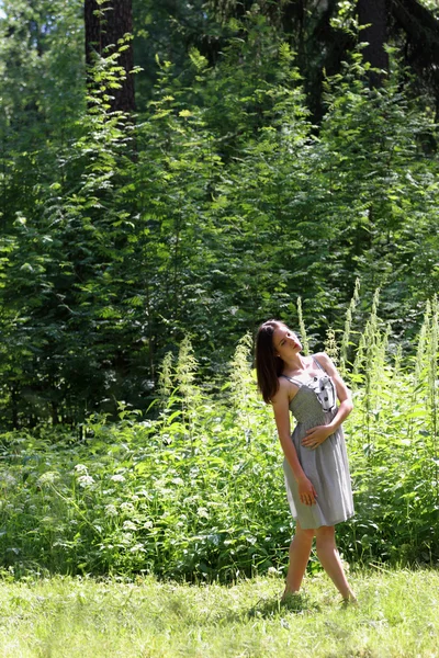 ता दरम्यान जंगलात उभे लांब केस असलेल्या ड्रेसमध्ये सुंदर मुलगी — स्टॉक फोटो, इमेज