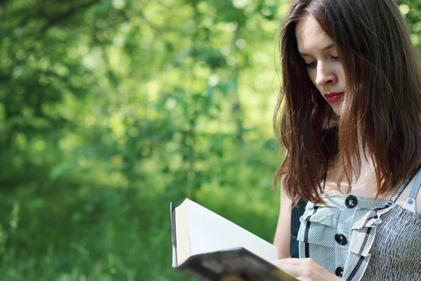 Primo piano bbeautiful ragazza a piedi lettura libro sulla soleggiata giornata estiva — Foto Stock