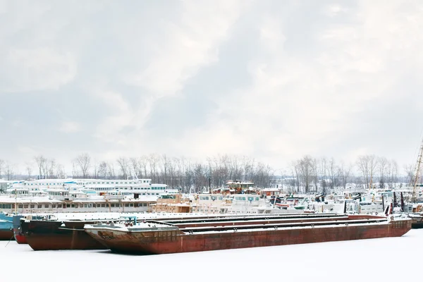 Vecchie e arrugginite grandi navi merci e passeggeri su fiume congelato a — Foto Stock