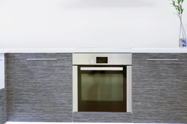 Horno empotrado en la nueva cocina moderna con muebles de madera gris — Foto de Stock