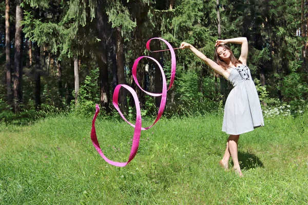 Mooi meisje in jurk, houdt zich bezig met ritmische gymnastiek met — Stockfoto