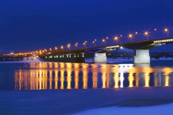 Ponte con lanterne e riflessione in acqua di fiume con ghiaccio a Immagine Stock