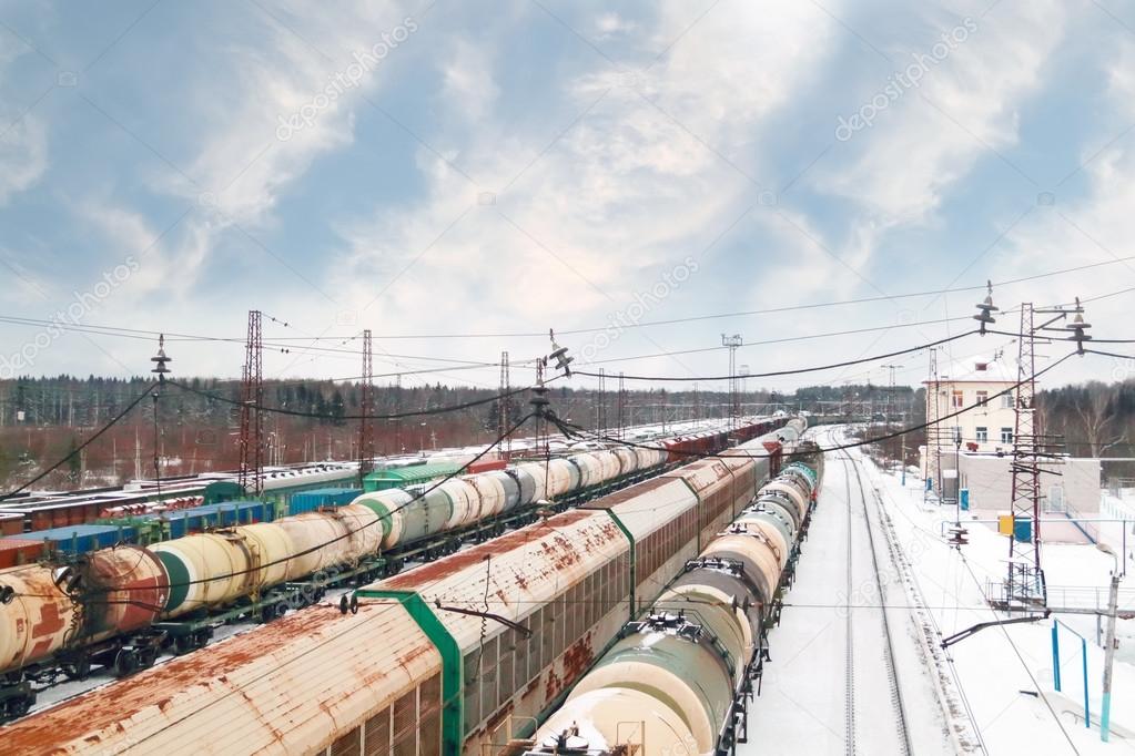Many long freight trains at railway station at winter day with c
