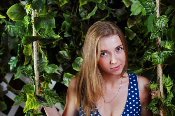 Closeup of beautiful girl with long blond hair sitting on swing — Stock Photo, Image