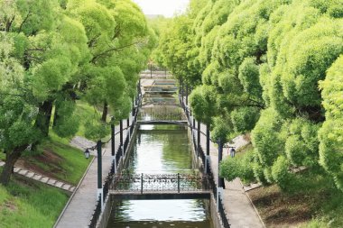 Yaz yeşil ağaçlar, kanal, sahte köprüler ile güneşli park ve 