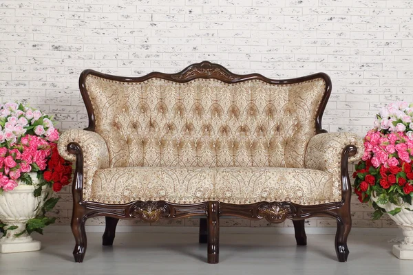 Camera vuota con divano vintage, muro di mattoni e bellissimi fiori — Foto Stock