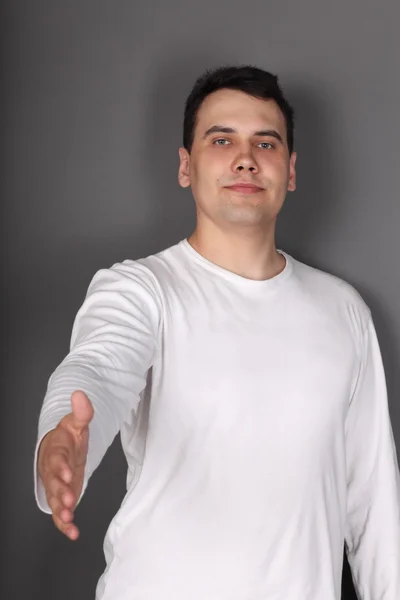 Young beautiful man holds out his hand for handshake — Stock Photo, Image