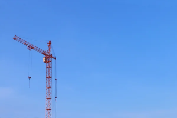 Großer orangefarbener Kran ohne Ladung auf blauem Himmel Hintergrund — Stockfoto