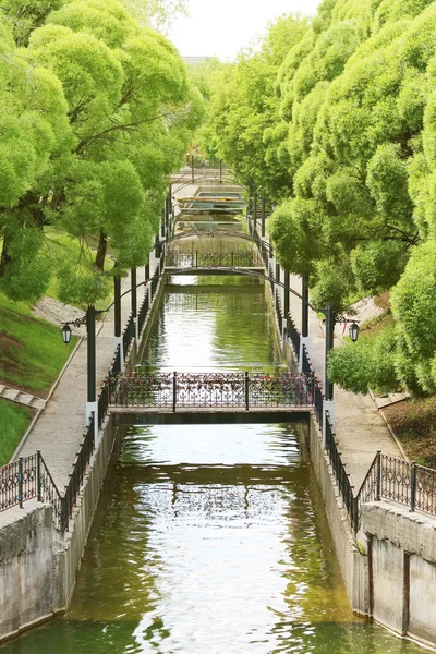 Летний солнечный парк с зелеными деревьями, канал, красивые мосты — стоковое фото
