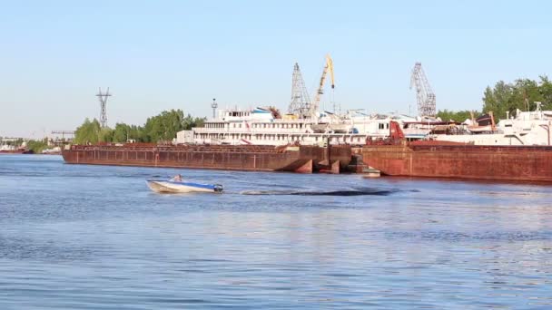 Pequeno barco flutua perto de grandes barcaças de carga e navios de passageiros no rio — Vídeo de Stock