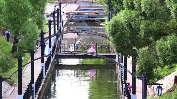 People in summer park with water channel and many bridges — Stock Video