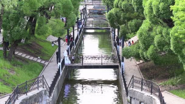 Människor i vacker park med vattenkanal och många broar — Stockvideo