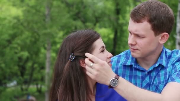 Mężczyzna pieszczoty kobietę i uderzeń jej włosy na zewnątrz w lecie — Wideo stockowe