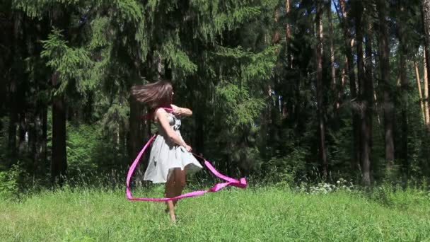 Νεαρή γυναίκα σε χορούς γκρι φόρεμα με κορδέλα στο δάσος καλοκαίρι — Αρχείο Βίντεο