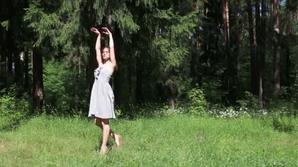 Mooi meisje in grijze jurk dansen in de zomer bos — Stockvideo