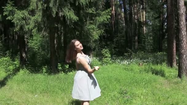 Счастливая девушка в платье в летнем лесу — стоковое видео