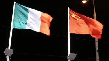 İtalya ve Çin bayrakları karanlık gecede rüzgarda aydınlatma ile