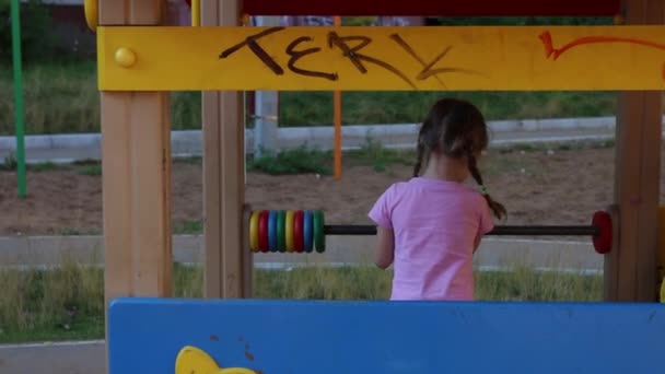 Yaz aylarında ahşap oyun alanında oynayan küçük güzel kızın arkası — Stok video