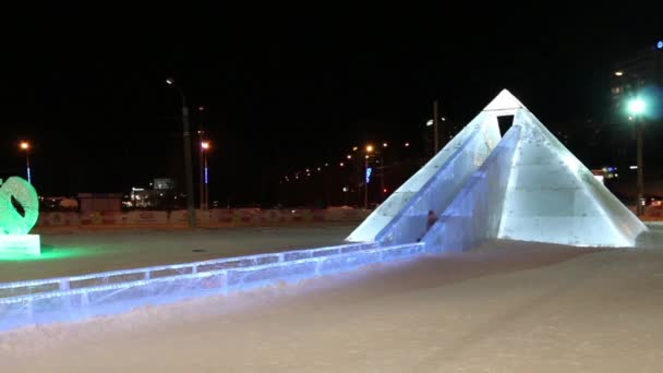 PERM, RUSIA - 15 ENE 2015: Pirámide de diapositivas iluminada en Ice Town por la noche. Coste de construcción y mantenimiento de la ciudad - 583 000 dólares — Vídeos de Stock