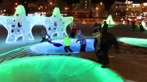 PERM, RUSIA - 15 ENE 2015: Personas en círculos de hielo iluminados Pirámide en Ice Town por la noche. Coste de construcción y mantenimiento de la ciudad - 583 000 dólares — Vídeo de stock