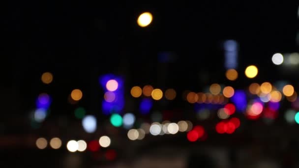 Moving cars and buildings with illumination at night city out of focus — Stock Video