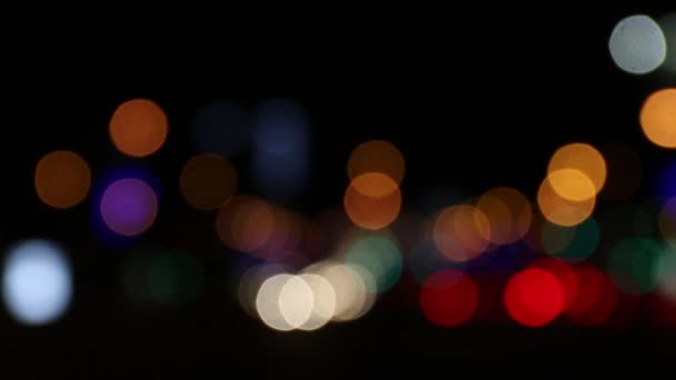 Перемещение автомобилей и зданий с освещением в ночном городе вне фокуса. Переменная неглубокая глубина резкости — стоковое видео