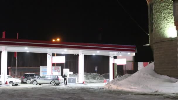 Los coches llegan a la gasolinera y repostan por la noche en invierno. Caducidad — Vídeo de stock