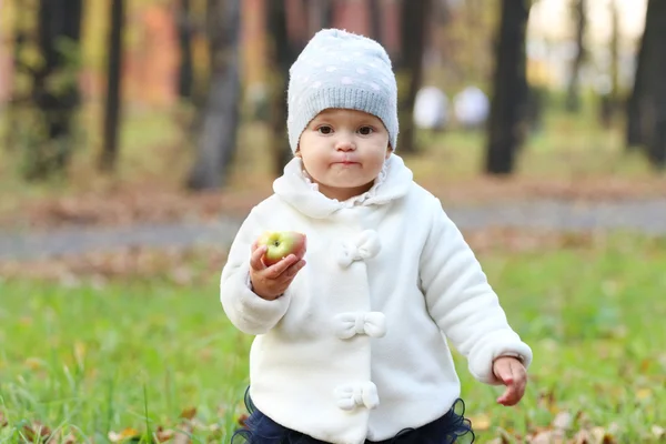 Little cute girl in white holds apple — Stock Photo, Image