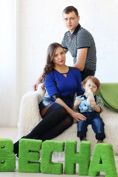 Madre, padre e figlioletto si siedono sul divano bianco nella stanza luminosa n — Foto Stock