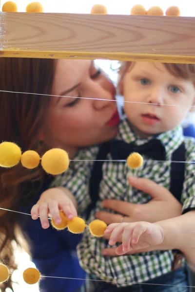 Mutlu anne perde arkasında küçük yakışıklı oğlu kisses — Stok fotoğraf
