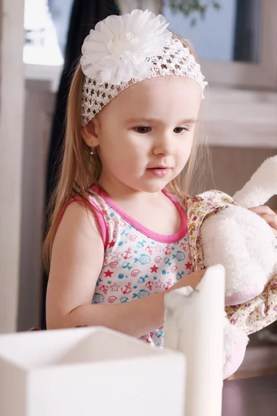 Pequeña linda chica rubia con diadema blanca sosteniendo juguete de peluche —  Fotos de Stock