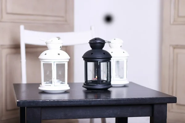 Trois luminaires deux blancs et un noir sur table en bois noir. S — Photo