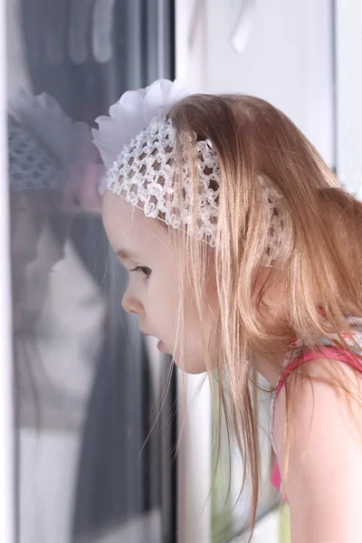 Closeup of cute little blond girl with white bandage looking out — Stock Photo, Image