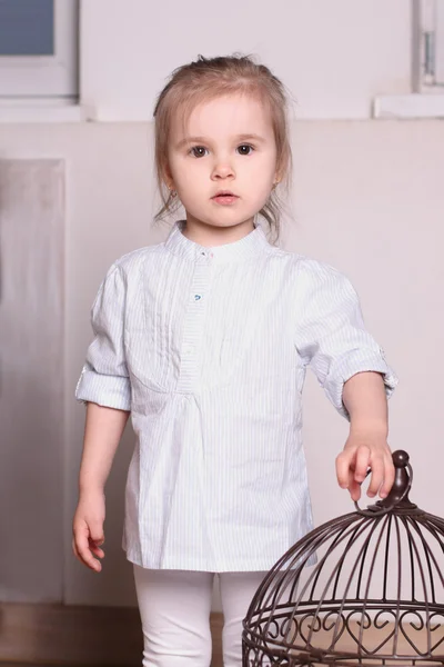 Little cute blond girl in striped shirt stands and extends hand — Stock Photo, Image