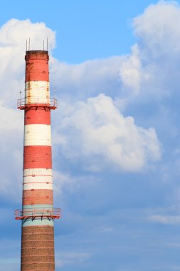 Uzun boylu baca kırmızı ve beyaz boru modern tesislerin ve mavi gökyüzü