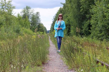 Güzel kadın mavi hindiba çiçek ile yürüyor