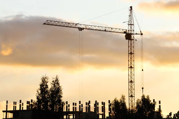 Silhouette von Kran und im Bau befindlichem Gebäude am Abend — Stockfoto