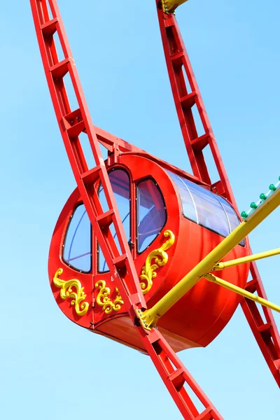 Red cabin of colorful Ferris wheel and blue sky with clouds — Stock Photo, Image