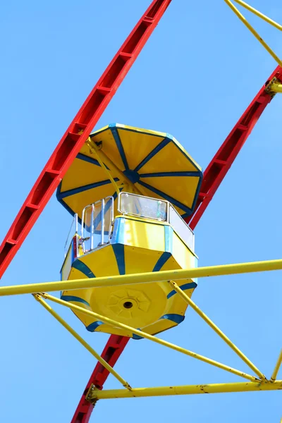 Gele cabine van kleurrijke reuzenrad en heldere blauwe hemel — Stockfoto