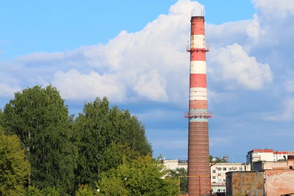 Hohes Kaminrohr moderner Pflanze inmitten grüner Bäume in der Stadt — Stockfoto